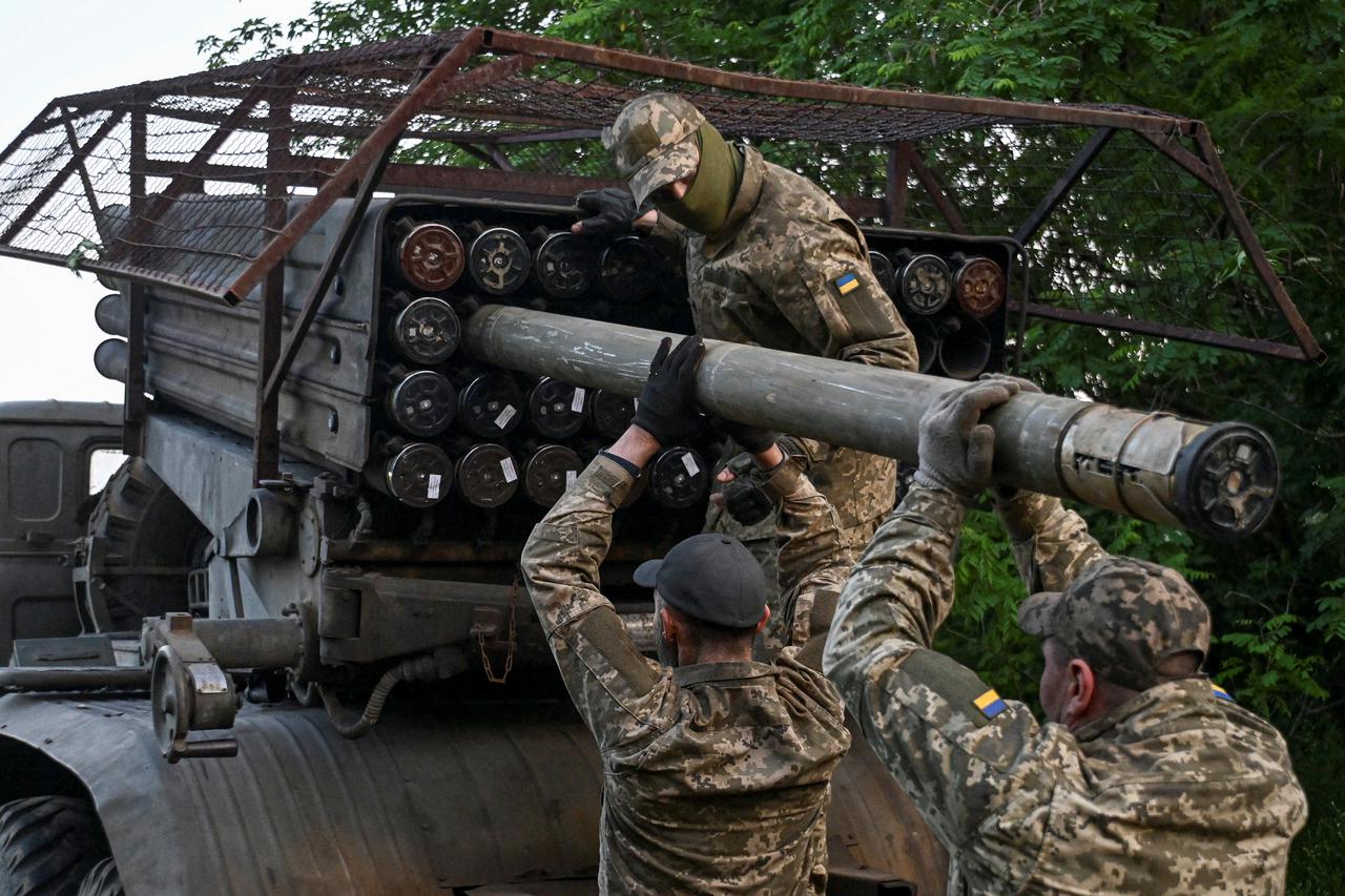 Ukrainian servicemen load a rocket into a multiple launcher before firing towards Russian troops on a front line in Zaporizhzhia region